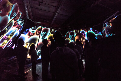 an audience in a room filled with large projections